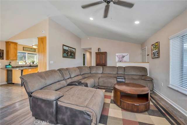 living room with light hardwood / wood-style flooring, ceiling fan, lofted ceiling, and sink