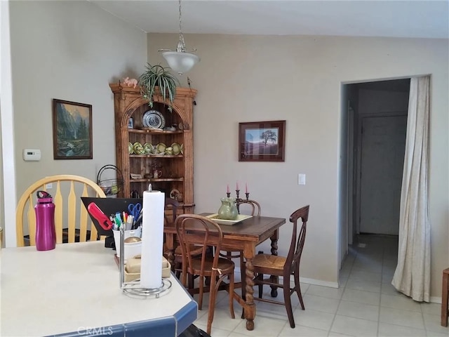 tiled dining space with vaulted ceiling