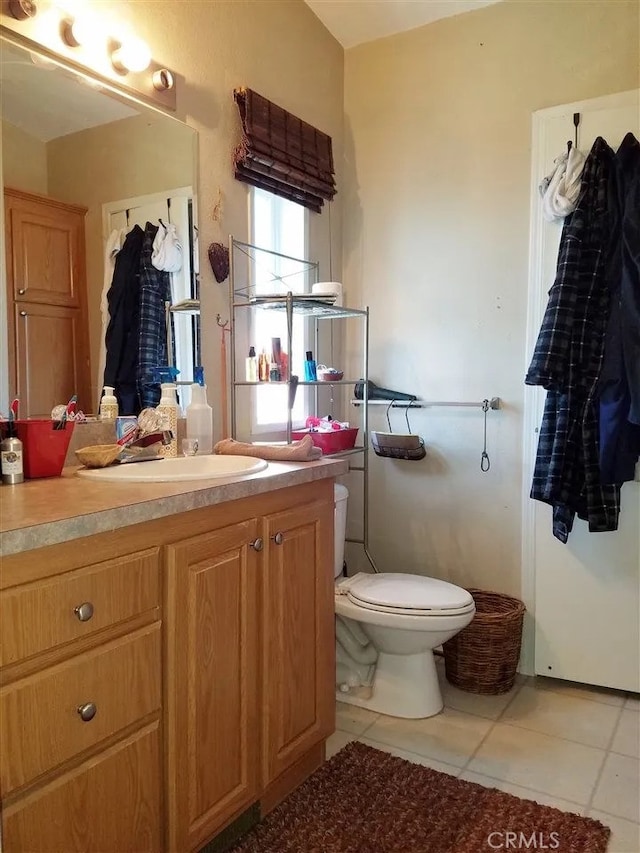 bathroom with tile patterned flooring, vanity, and toilet