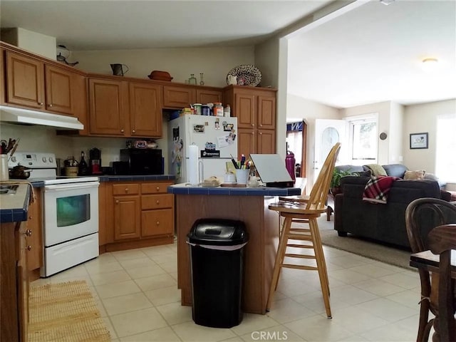 kitchen with a kitchen island, a kitchen bar, white appliances, and vaulted ceiling