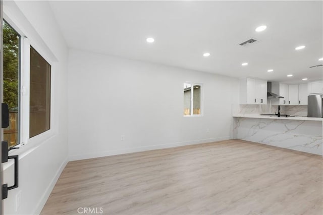 unfurnished living room with light wood-type flooring and sink