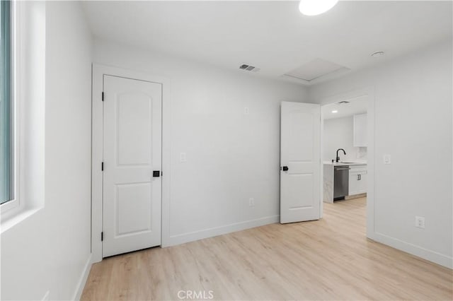 unfurnished room featuring light hardwood / wood-style floors and sink