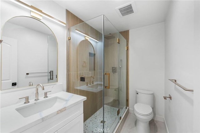 bathroom with a shower with door, vanity, and toilet