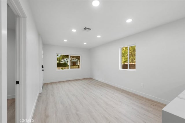 unfurnished room featuring a wealth of natural light and light hardwood / wood-style floors