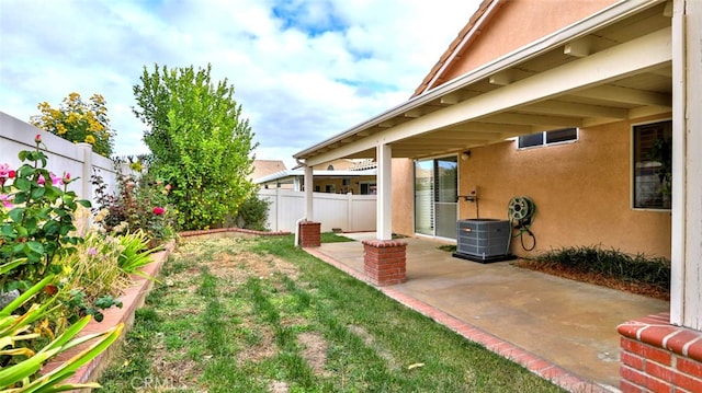 view of yard with central AC unit and a patio