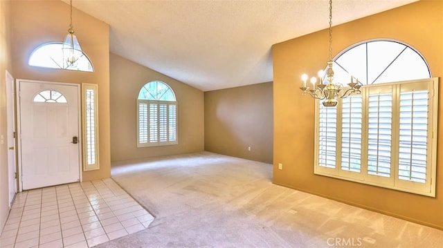 entrance foyer with a textured ceiling, carpet floors, an inviting chandelier, and a healthy amount of sunlight