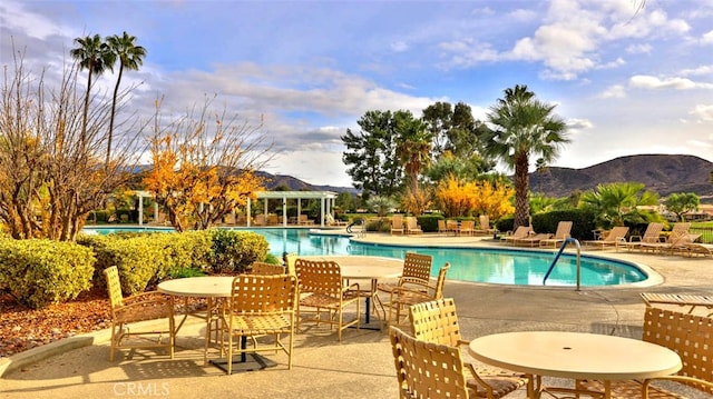 view of pool with a mountain view and a patio