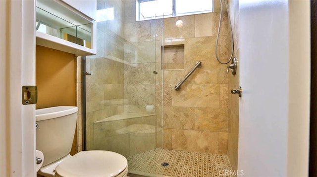 bathroom featuring toilet and a shower with shower door