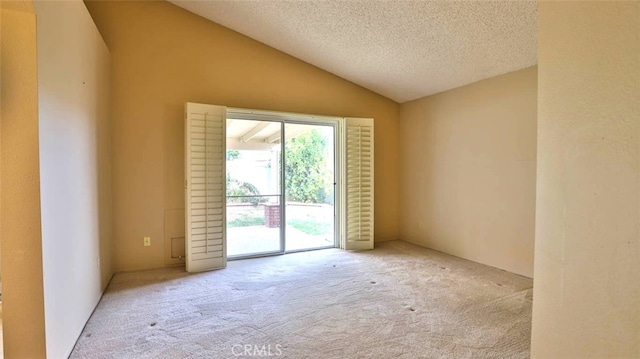 carpeted spare room with a textured ceiling and lofted ceiling