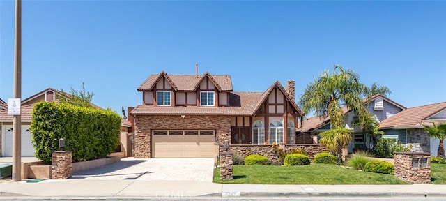 tudor house featuring a front yard and a garage