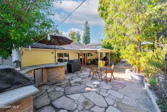 view of patio with an outdoor kitchen and area for grilling