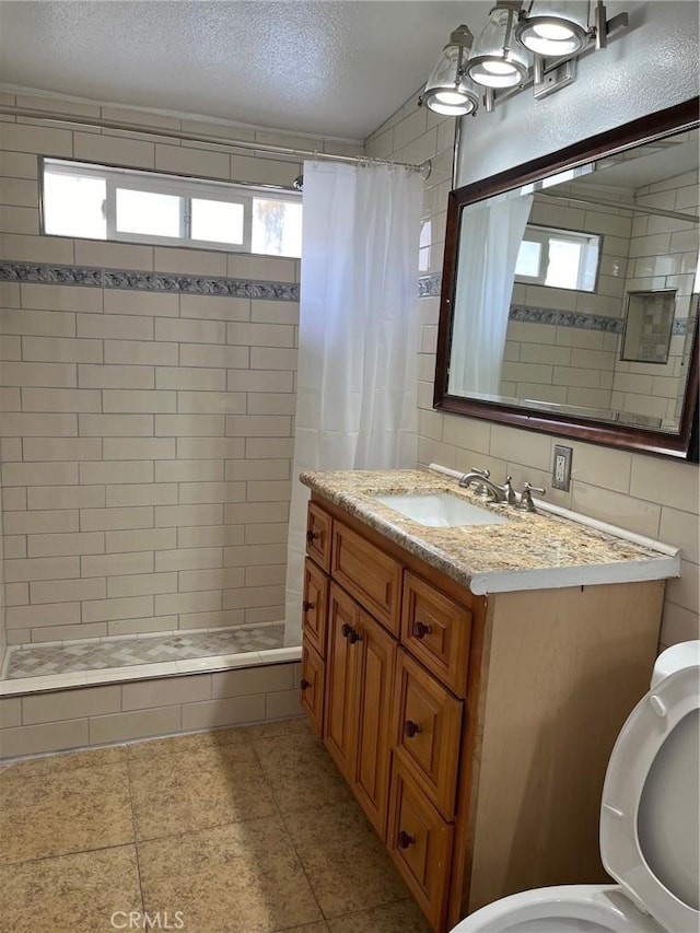 bathroom with tile patterned floors, vanity, a textured ceiling, and a shower with shower curtain