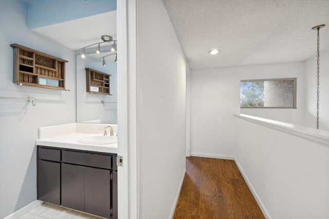 bathroom with vanity, wood-type flooring, and a textured ceiling