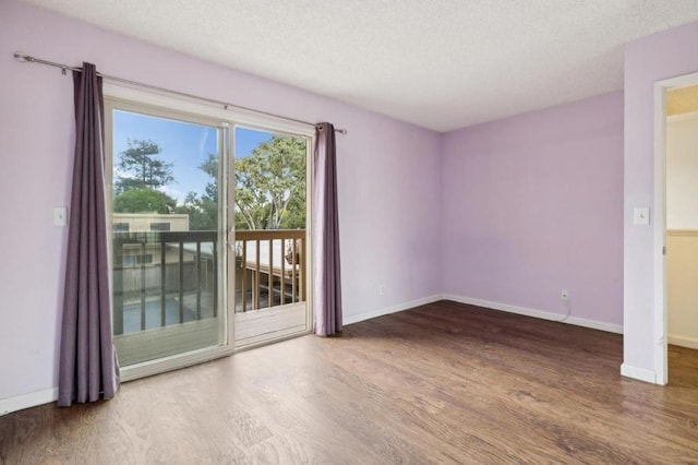 unfurnished room with hardwood / wood-style floors and a textured ceiling