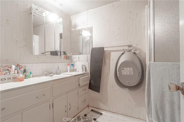 bathroom with vanity and tile walls