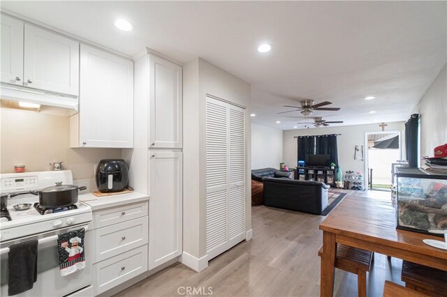 kitchen featuring light hardwood / wood-style floors, ceiling fan, white cabinetry, and white range with gas stovetop