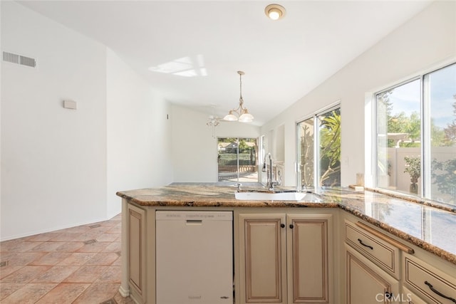 kitchen featuring white dishwasher, decorative light fixtures, light stone countertops, and sink