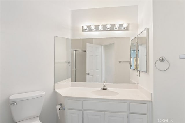 bathroom with vanity, an enclosed shower, and toilet