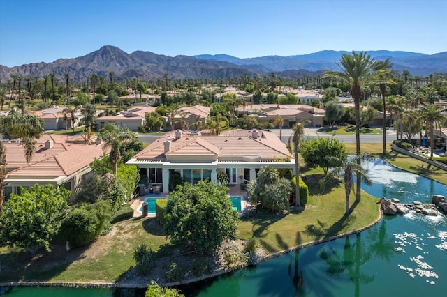 birds eye view of property with a water and mountain view