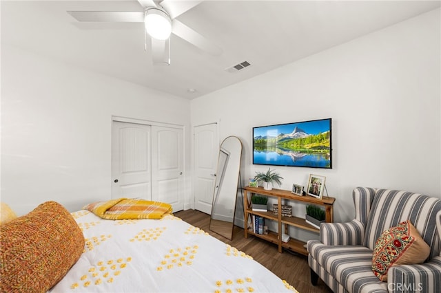 bedroom with ceiling fan, a closet, and dark wood-type flooring