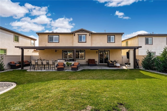 rear view of property featuring a lawn, a patio area, and an outdoor hangout area