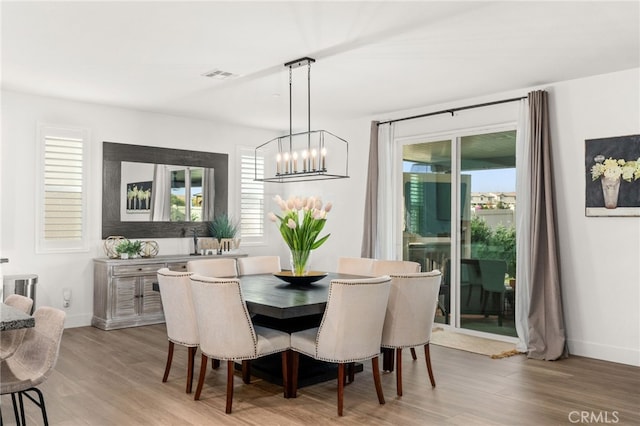 dining space featuring light hardwood / wood-style floors and a notable chandelier