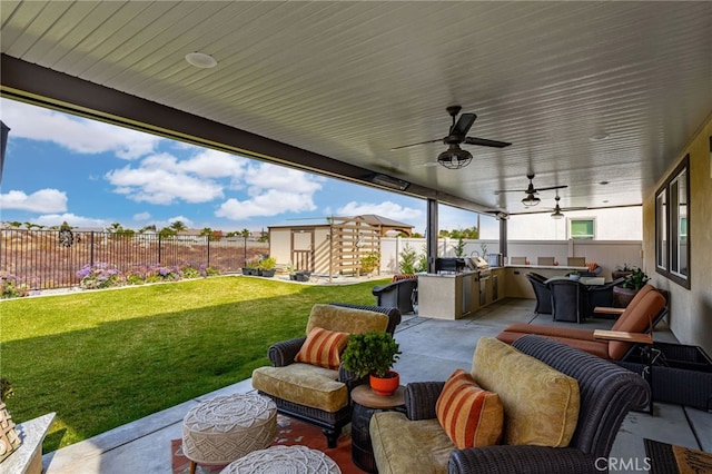 view of patio / terrace featuring an outdoor kitchen, ceiling fan, a shed, and an outdoor living space