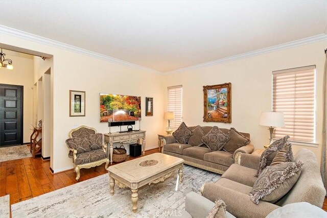 living room featuring hardwood / wood-style floors, a chandelier, and ornamental molding