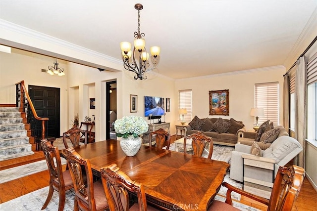 dining area with crown molding, wood-type flooring, and an inviting chandelier