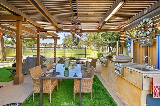 view of patio with area for grilling, a pergola, and sink