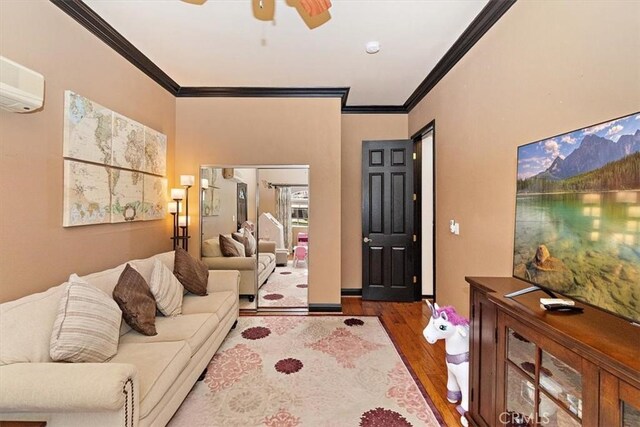 living room with a wall mounted AC, crown molding, ceiling fan, and hardwood / wood-style flooring