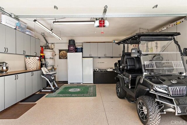 garage with white fridge and a garage door opener