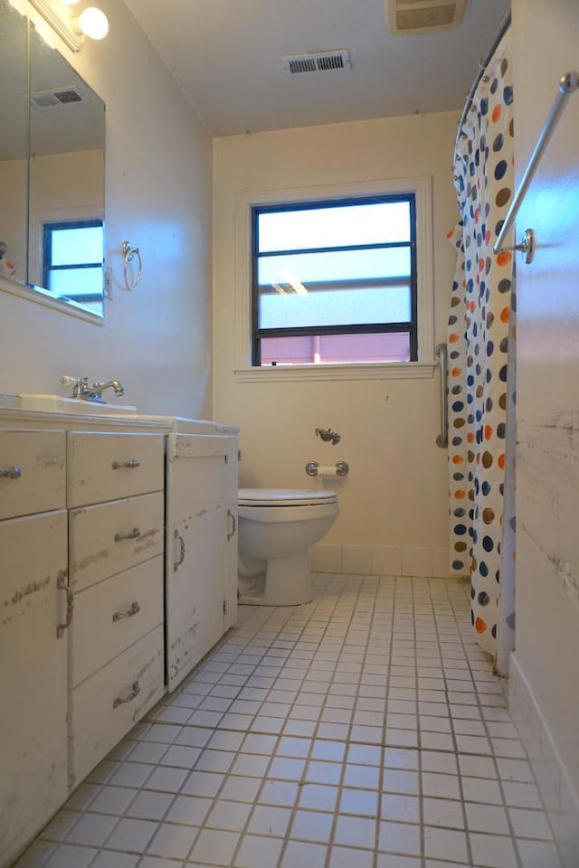 bathroom featuring toilet, vanity, and tile patterned flooring