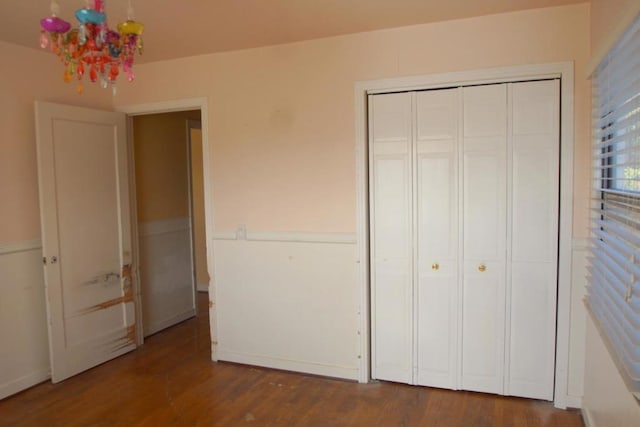 unfurnished bedroom with a closet and dark hardwood / wood-style floors