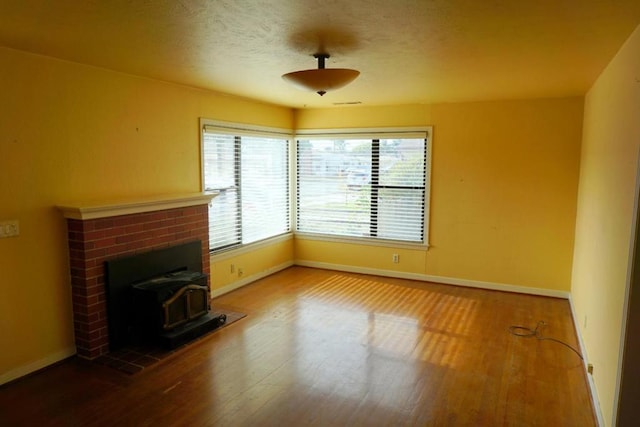 unfurnished living room with a wood stove and wood-type flooring