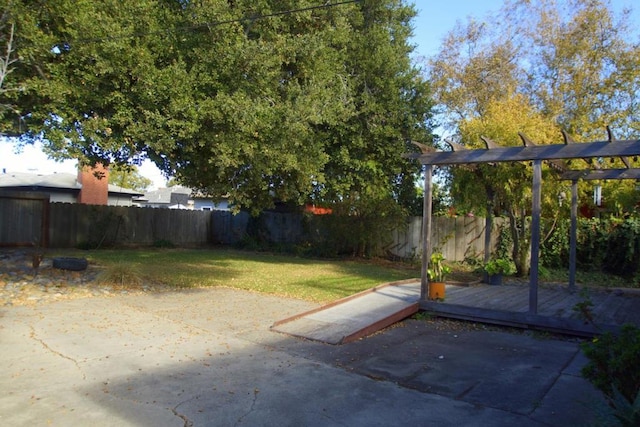 view of yard featuring a deck, a pergola, and a patio