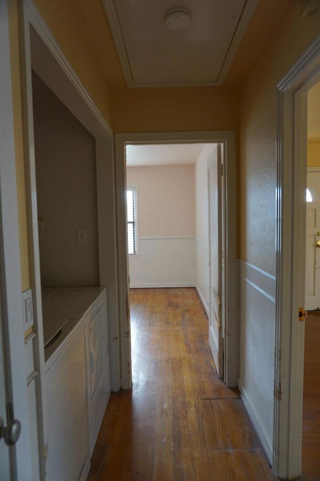 hallway with light wood-type flooring and washer and dryer