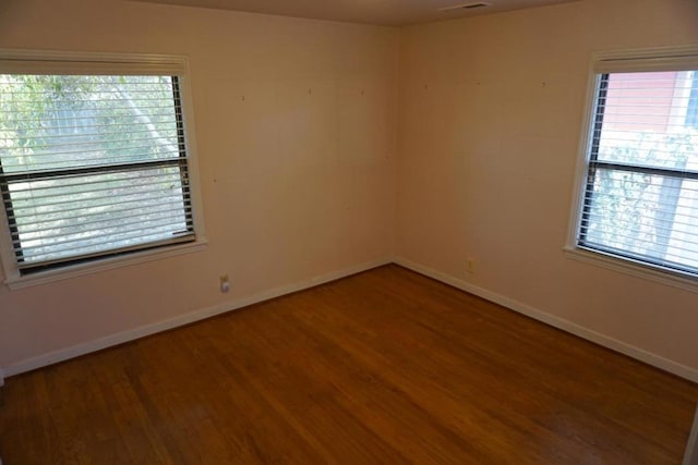 empty room featuring wood-type flooring and a wealth of natural light