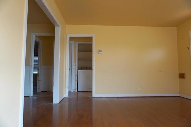 unfurnished room featuring built in features, wood-type flooring, and washer / clothes dryer