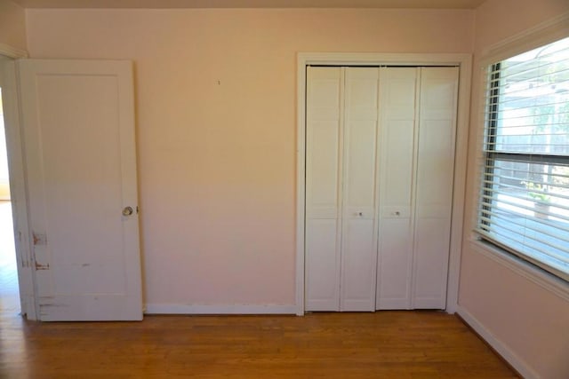 unfurnished bedroom featuring a closet and hardwood / wood-style floors