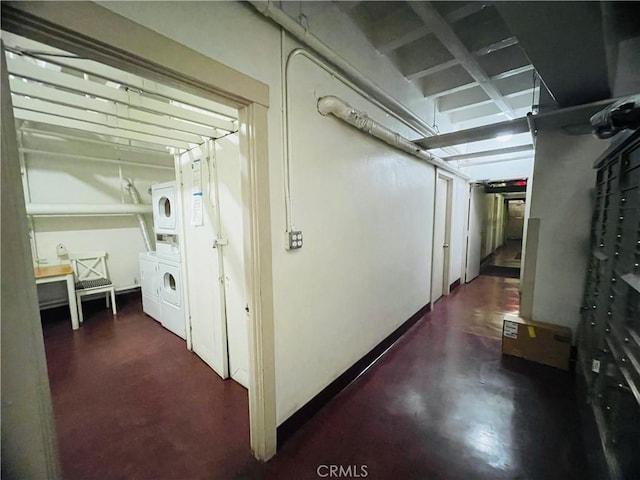 hallway featuring stacked washer and dryer