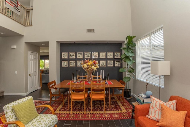 dining area with a high ceiling and a wealth of natural light