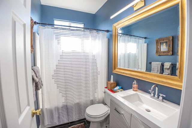 bathroom with tile patterned floors, a healthy amount of sunlight, toilet, and vanity