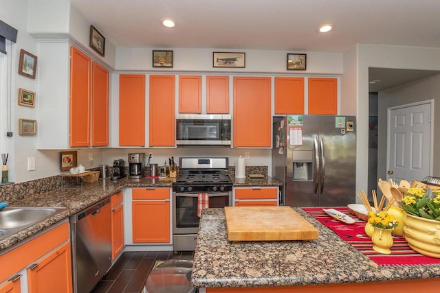 kitchen with appliances with stainless steel finishes, sink, and dark stone counters