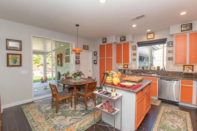 kitchen featuring a healthy amount of sunlight, dishwasher, sink, and hanging light fixtures