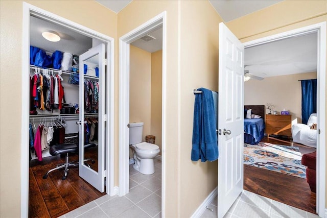 bathroom featuring hardwood / wood-style flooring, toilet, and ceiling fan