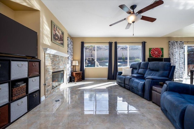 living room featuring a tile fireplace and ceiling fan