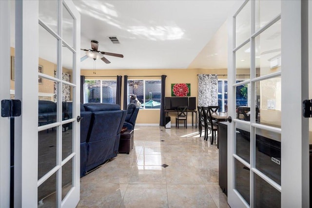 living room featuring ceiling fan and french doors