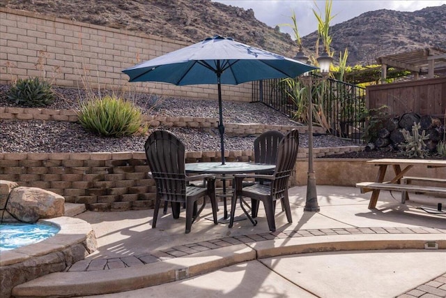 view of patio featuring a mountain view and a hot tub