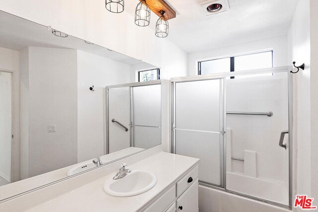 bathroom featuring vanity and combined bath / shower with glass door